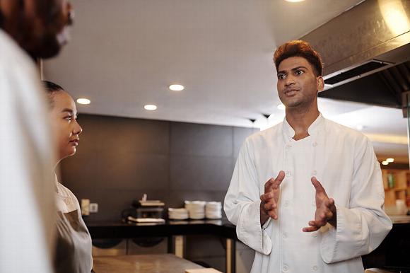Kitchen manager talking with cooks