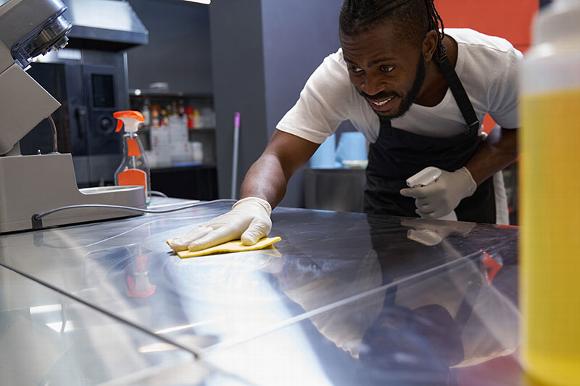 man cleaning kitchen after hours
